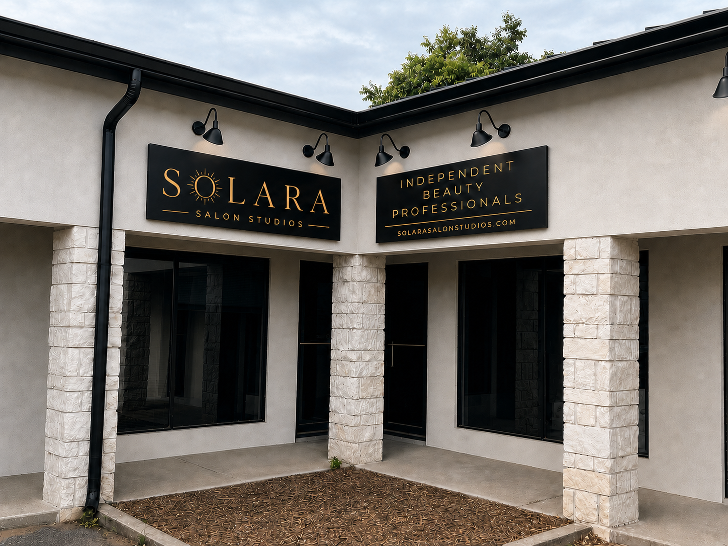 The Solara Salon Studios storefront: gold wordmark on black sign panels above stone columns.